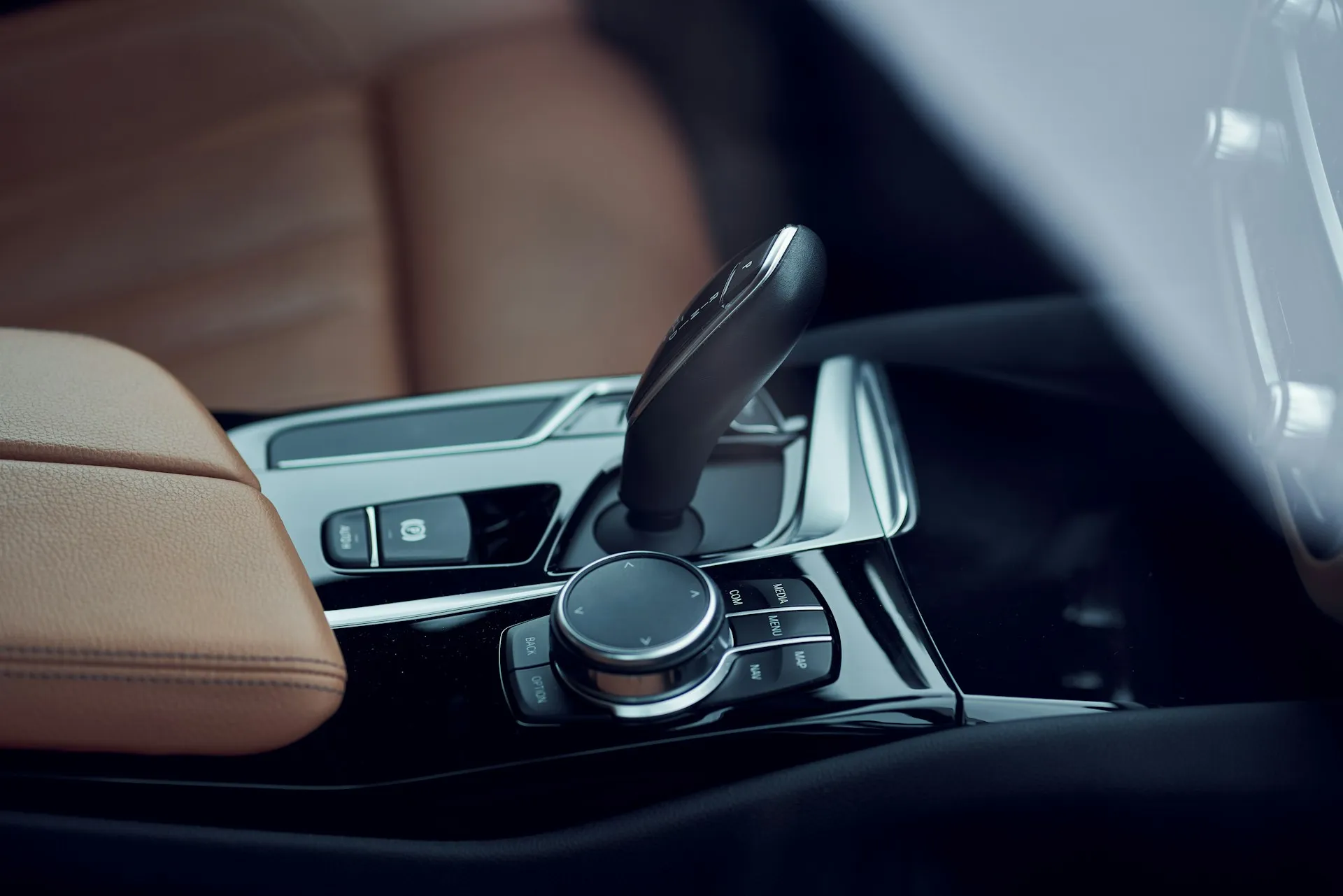 Photograph of the center console of a modern car interior through the side window.
