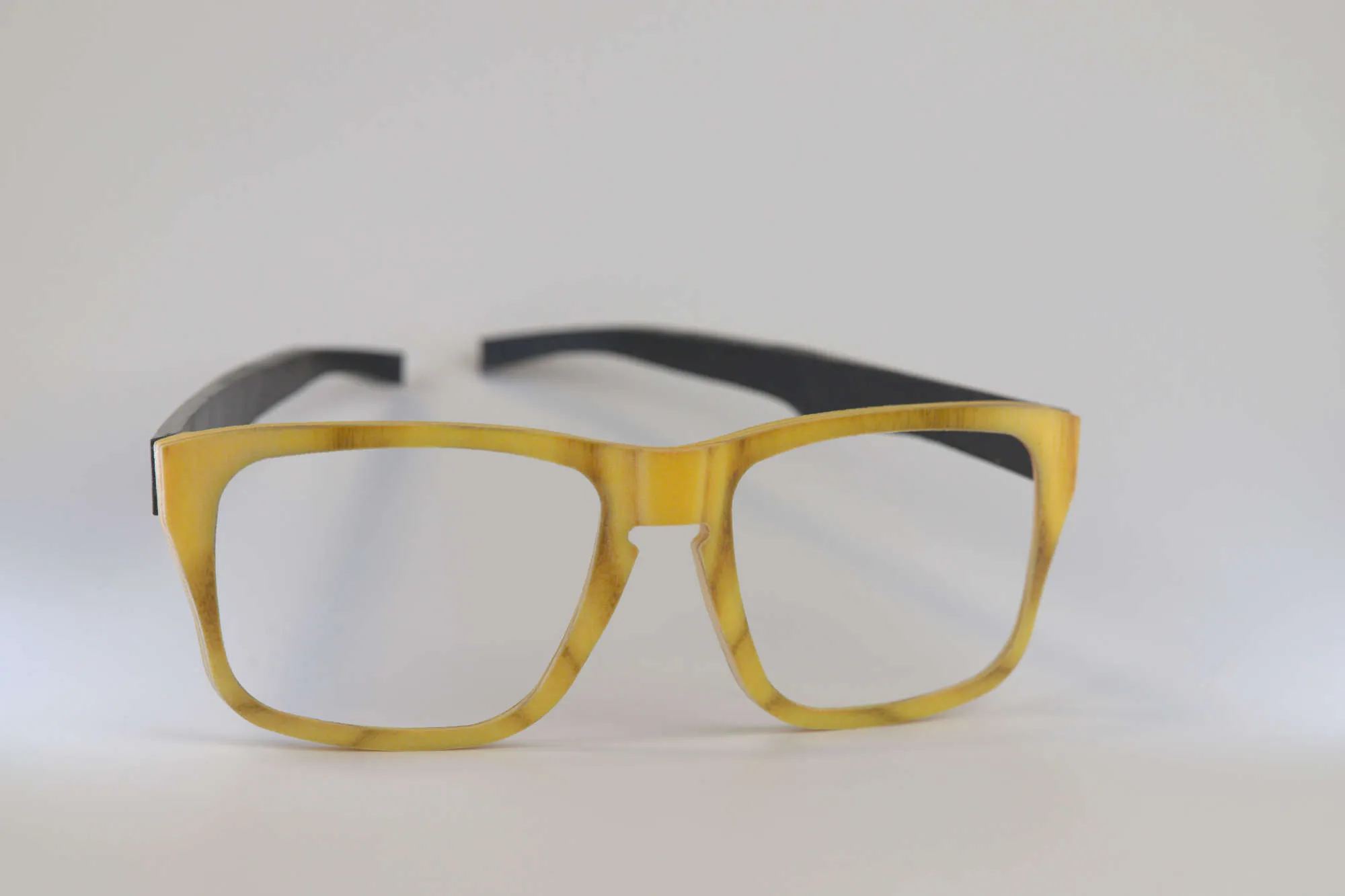 A 3D printed eye glasses frame with a wooded texture and black ear
pieces.